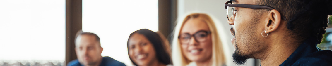 Professional bespreekt met collega's de samenwerking tijdens een teamoverleg.