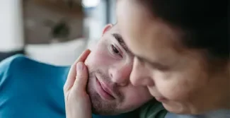 twee hoofden van een moeder en zoon die tegen elkaar leunen, de moeder heeft haar hand op de kin van de zoon